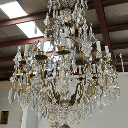 Louis XV 18th Century important cage shaped Castle Chandelier with 12 bronze scones and adorned with 8 daggers and large cut crystal prisms and the barrel threaded with cut glass pieces and finished with a large glass ball. The chandelier has beautiful proportions and is very well balanced in its arrangement of the crystals etc. The chandelier was sourced from Paris and comes with the majority of its original crystals intact. There are 6 internal lights and combined with the 12 sconces offers a dazzling arr