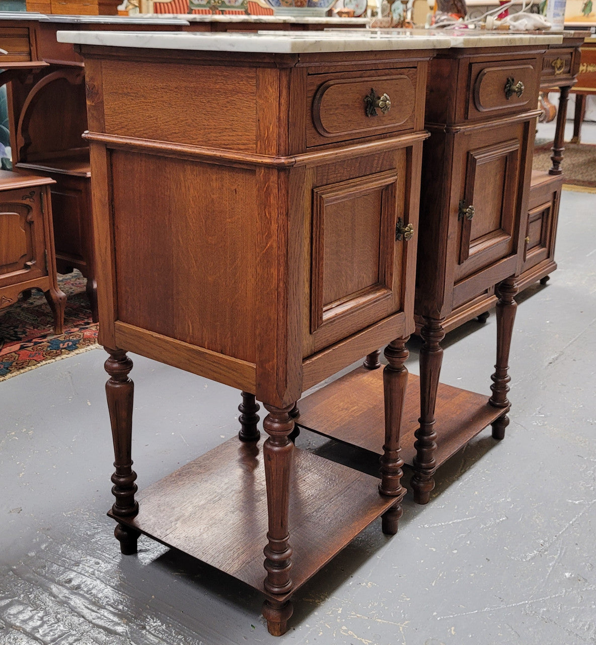 Antique French Oak Henry II white marble top bedside cabinets. They have one drawer and cupboard a long with an open shelf at the bottom. Sourced from France and in good original detailed condition.