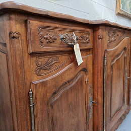 Parquetry top French oak Louis XV style sideboard with two draws and four cupboards. In good original detailed condition.