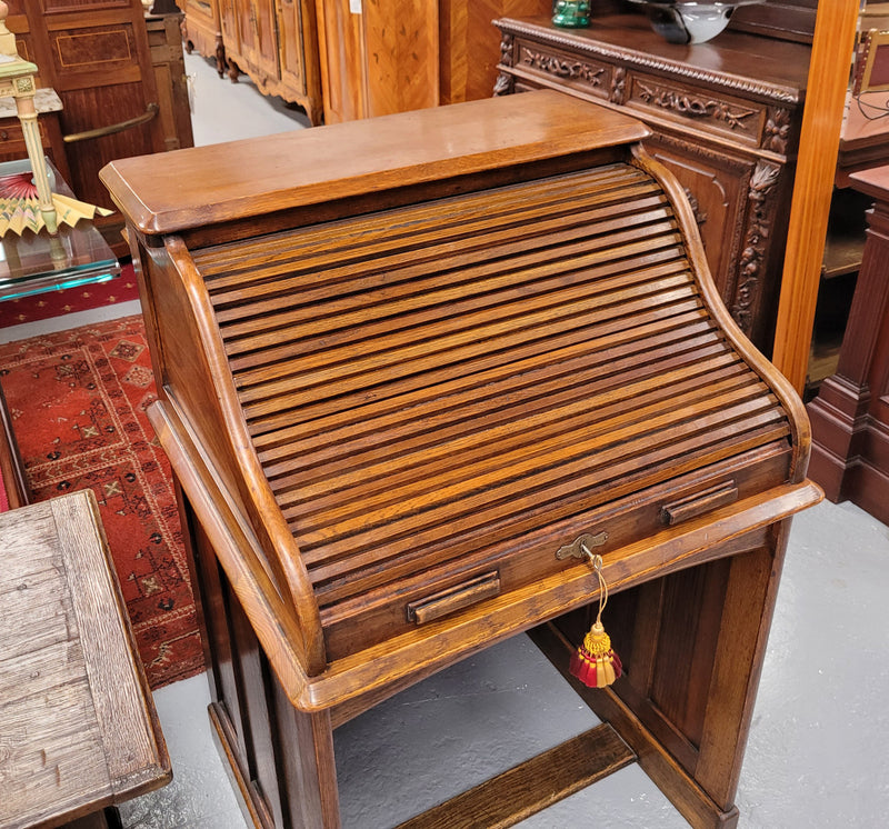 Charming petite English Oak fitted roll top desk. It has a very lovely fitted interior and a drawer at the front ideal for a unit or apartment. Sourced locally and in good original detailed condition.