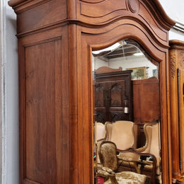 French Louis XV style Walnut armoire with single bevelled mirrored door. It has four adjustable shelves and a hidden exterior drawer at the bottom. It has been sourced from France and is in good original detailed condition.