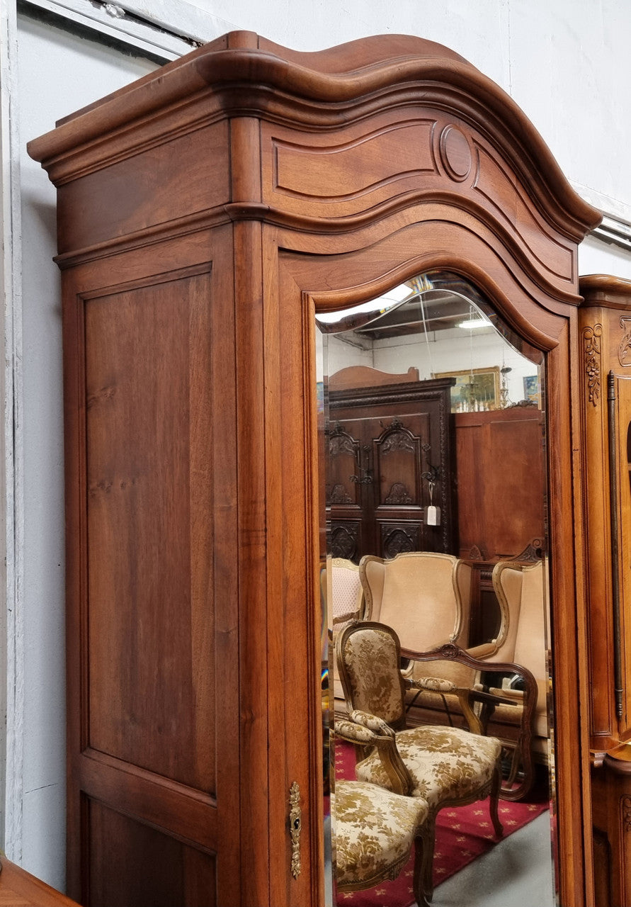 French Louis XV style Walnut armoire with single bevelled mirrored door. It has four adjustable shelves and a hidden exterior drawer at the bottom. It has been sourced from France and is in good original detailed condition.