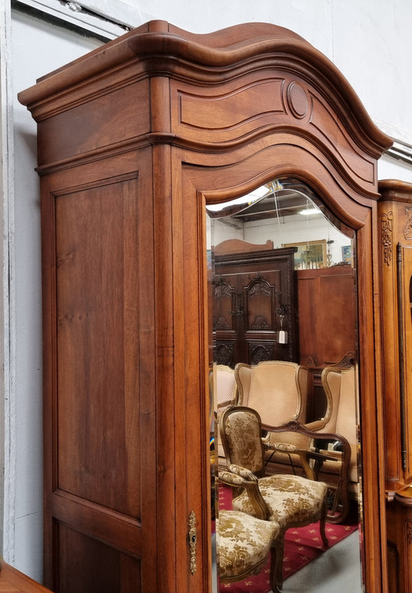 French Louis XV style Walnut armoire with single bevelled mirrored door. It has four adjustable shelves and a hidden exterior drawer at the bottom. It has been sourced from France and is in good original detailed condition.