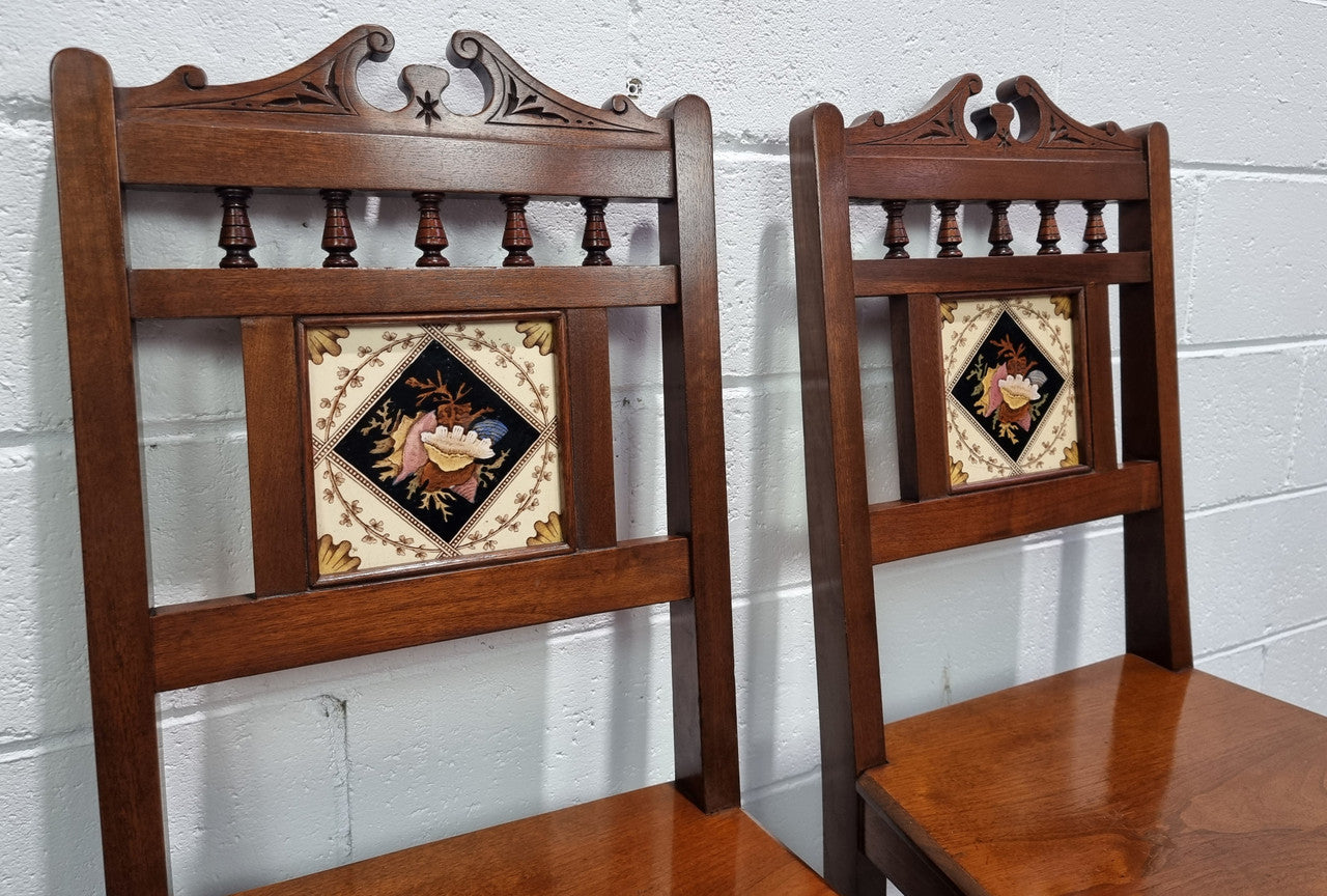 Pair of Edwardian Mahogany hall chairs with original tile in back. They are in very good original detailed condition.
