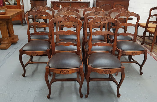A set of ten French Louis XV style, ladder back oak chairs. With finely carved detail and newly upholstered leather look seat. In great original condition. Chairs are comfortable and sturdy for everyday use.