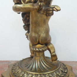 An antique signed French gilt bronze cupid candlestick in good original condition.