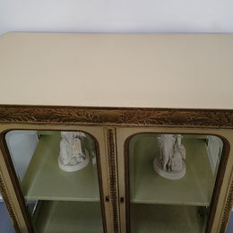 19th Century painted and gilt two door vitrine. Has one adjustable shelf and two drawers. In good original detailed condition.