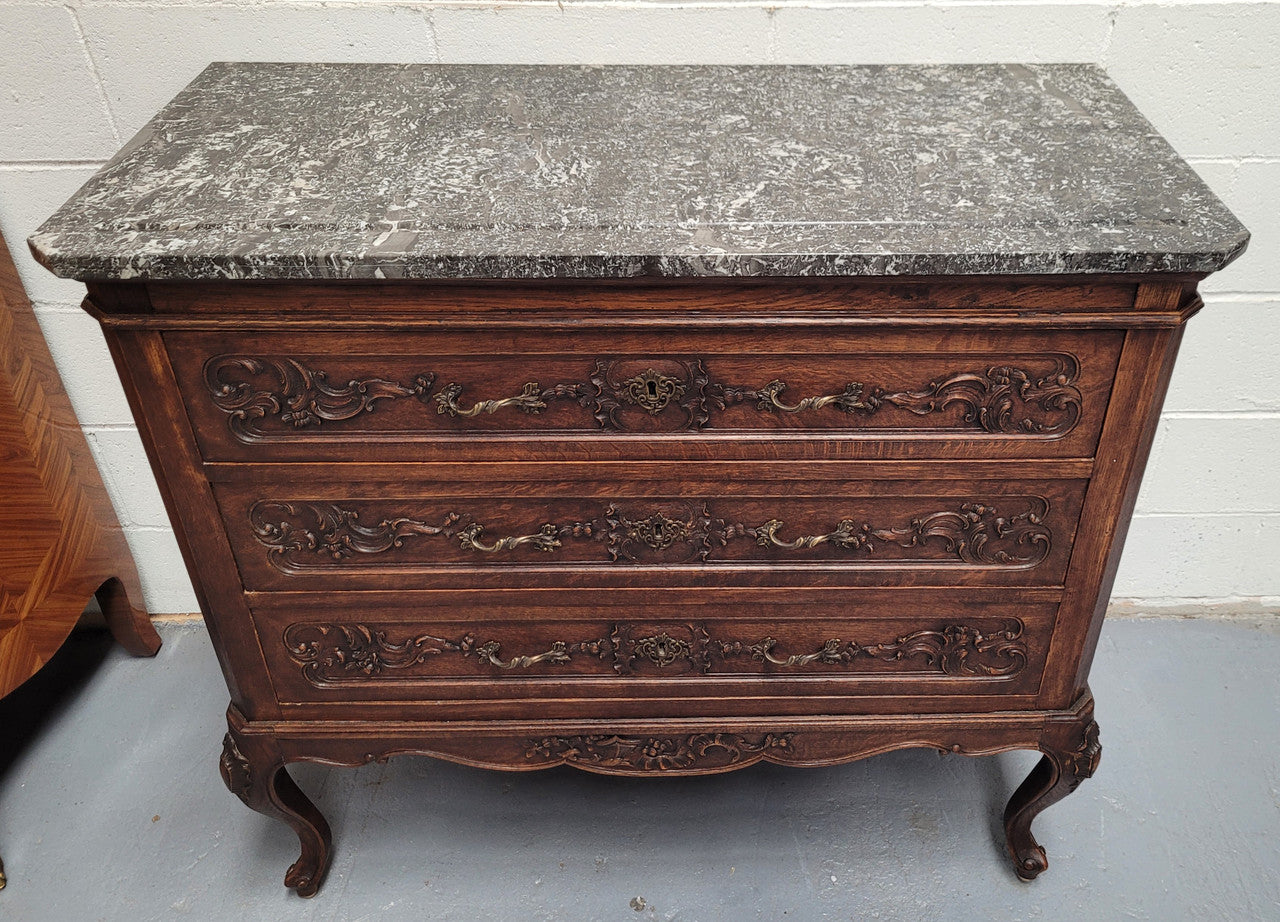 French Oak Louis XV style marble top chest of three drawers. It has beautiful carvings on the drawers with lovely decorative handles all toped with a stunning black and white marble top. In good original detailed condition.