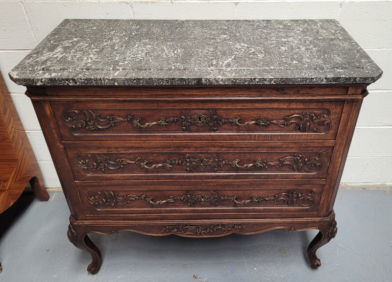 French Oak Louis XV style marble top chest of three drawers. It has beautiful carvings on the drawers with lovely decorative handles all toped with a stunning black and white marble top. In good original detailed condition.