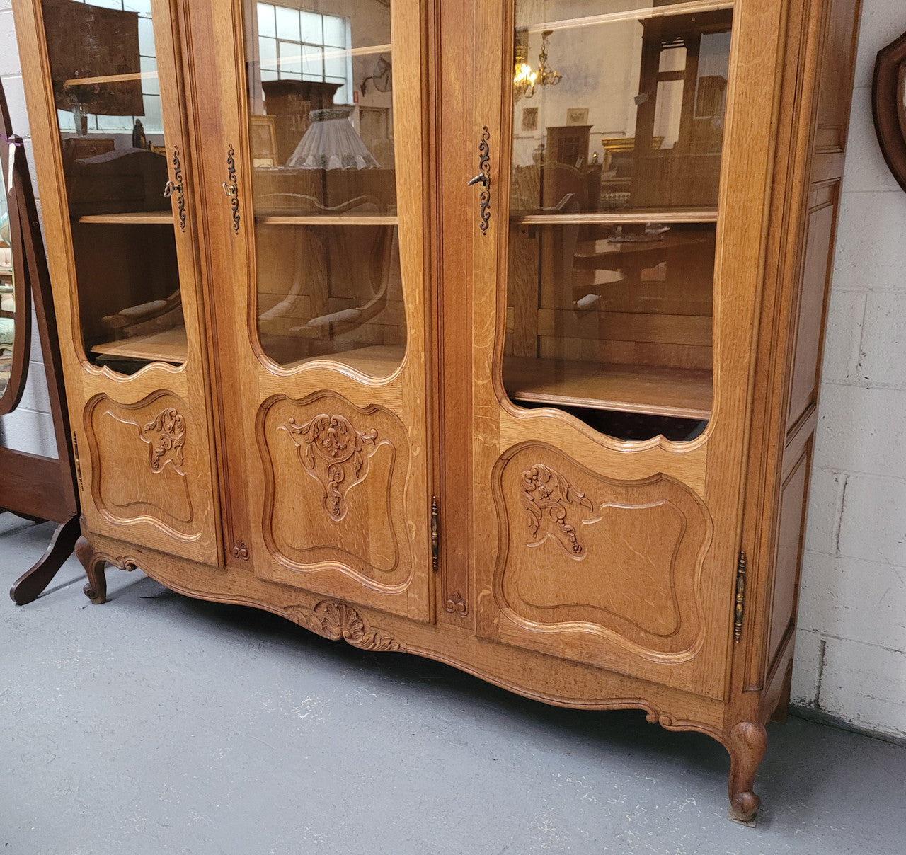 French Louis XV style light Oak three door bookcase with five fixed shelves. It has lovley glass doors and has been sourced from France. Is in good original detailed condition