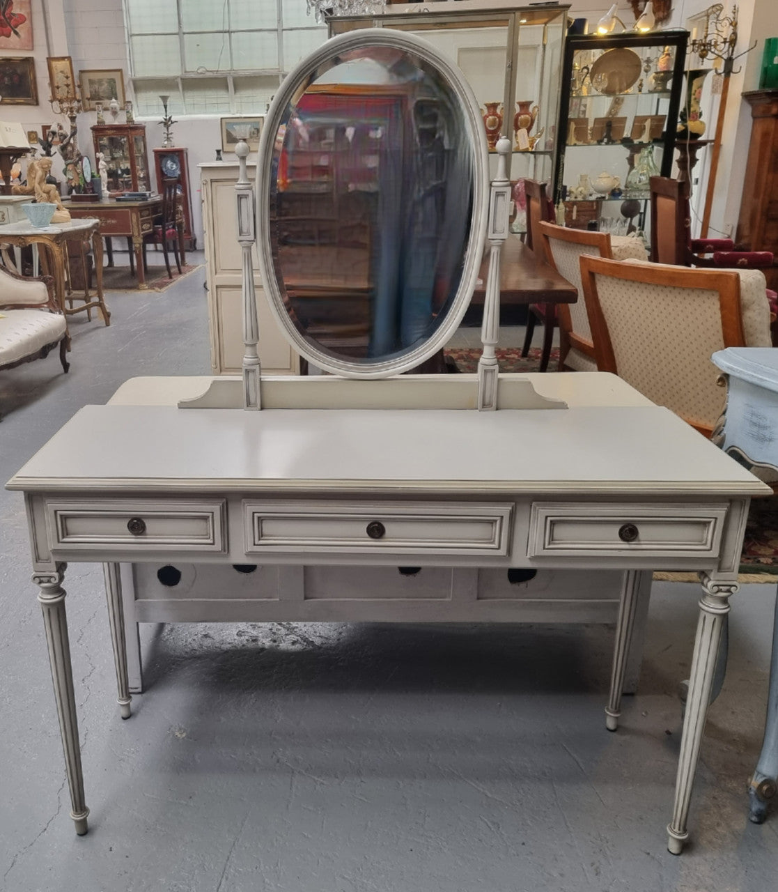 French Louis XVI style painted dresser / console with beveled oval mirror and three drawers. Sourced from France and in good original detailed condition.