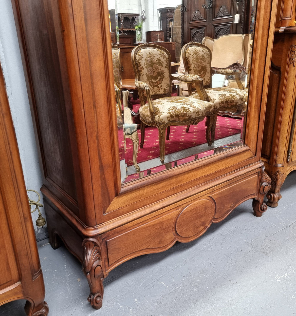 French Louis XV style Walnut armoire with single bevelled mirrored door. It has four adjustable shelves and a hidden exterior drawer at the bottom. It has been sourced from France and is in good original detailed condition.