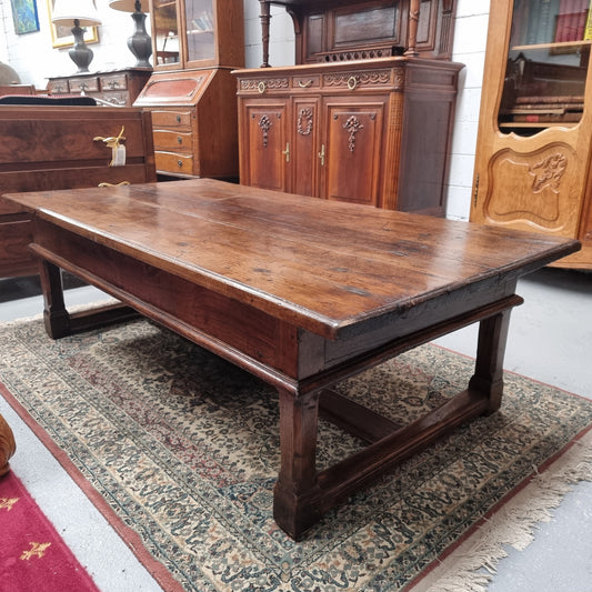 Impressive large size rustic French Oak coffee table with two drawers on a stretcher base. In good original detailed condition and sourced from France.