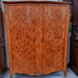 Charming French Louis XV Style Marquetry Inlaid Two Door Armoire. Features three adjustable shelves and ormolu trim. It has been sourced from France and is in good original condition.