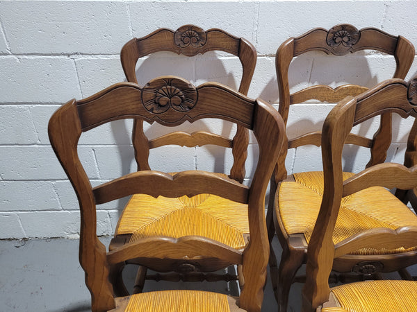 A set of 6 French Louis XV style oak dining chairs with rush seats in good original condition. All chairs have been detailed and re-glued where needed.