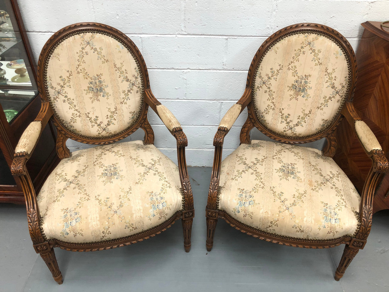 Pair of Antique French Louis XVI style carved Walnut fauteuils in restored condition. The Tapestry upholstery is in good condition some marks and wear but usable.