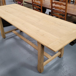 French raw Oak stretcher based refectory table. Features raw wood that could be used as is for a distressed look, or finished and waxed for a more refined look. Sourced from France and in good original condition.