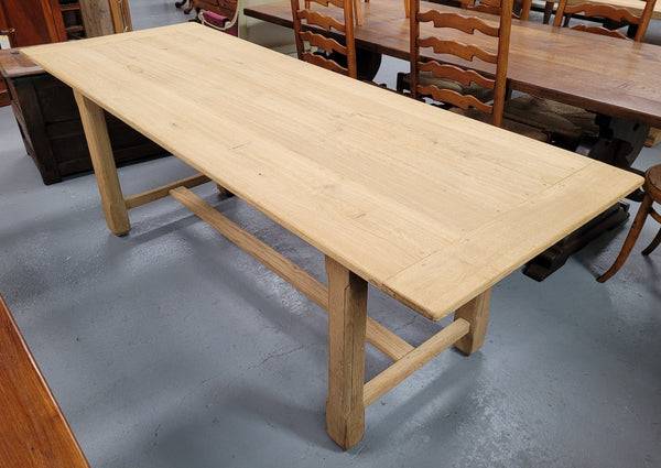 French raw Oak stretcher based refectory table. Features raw wood that could be used as is for a distressed look, or finished and waxed for a more refined look. Sourced from France and in good original condition.