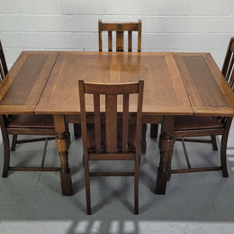 Fabulous small Oak extension table and four dining chairs. The table extends from a four seater to a six seater. The chairs have nice carvings and leather inset seats. They are in original detailed condition.