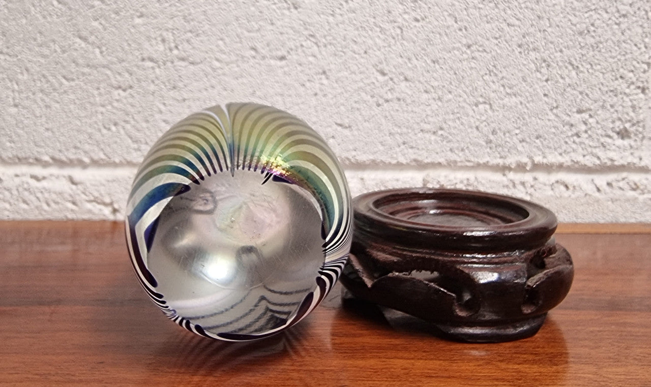 Iridescent glass egg shaped paper weight, on small wooden chinese stand. In good original condition. Please see photos as they form part of the description.