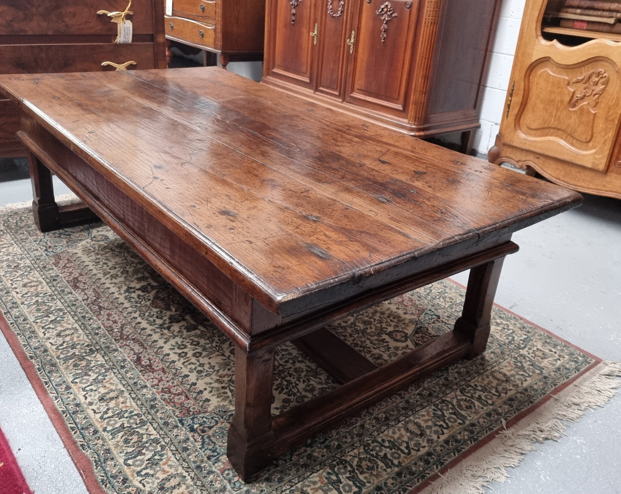 Impressive large size rustic French Oak coffee table with two drawers on a stretcher base. In good original detailed condition and sourced from France.