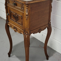 Beautiful French Walnut carved bedside cabinet with a lovely grey coloured inset marble top. The inside of the cupboard is also marble lined and it is in good original detailed condition.