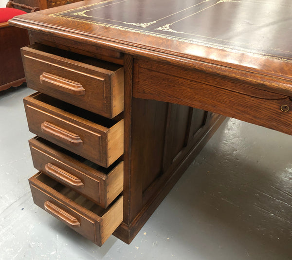 Lovely large English oak partners desk, with a beautiful burgundy tooled leather top. Plenty of storage space, both sides have 9 functioning drawers. It is in very good condition.