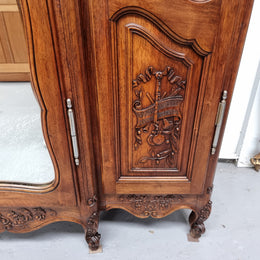 French Walnut Louis XV style three door armoire with 10 fully adjustable shelves in total spread over three sections, two drawers and a mirrored middle door. It has been sourced from France and in good original detailed condition.