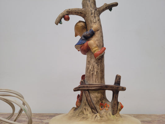 Charming Hummel Lamp featuring a young boy climbing an apple tree with a barking dog on the ground.  Incised Hummel mark on side of base and 44A on base with 1935 (copyright) and Goebel W Germany. Height without shade 33.5cm