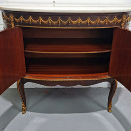 Vintage French style marble top two door half-moon buffet with beautiful decorative brass gilt mounts. In good original detailed condition.
