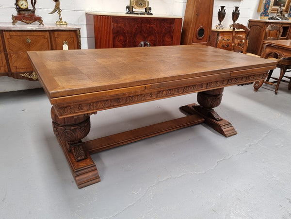 French Oak Renaissance style extension table with a stretcher base and heavily carved bulbous. When the table fully extends it measures 300 cm and can be used with both sides out or with only the one leaf out either side. It is in good original detailed condition.