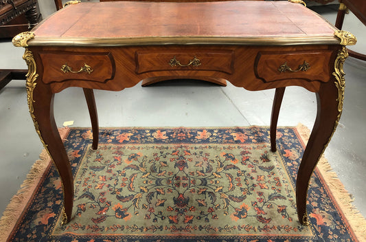 An impressive French Walnut petite Bureau Plat with superb ormolu mounts, original tooled leather top with loads of character and drawers for storage. It is in very good original detailed condition.