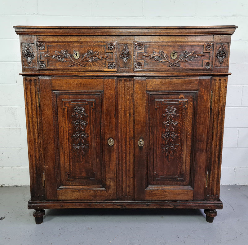 18th century French Oak Tall sideboard with beautiful carvings. It has plenty of storage with two drawers at the top and two doors at the bottom with a fixed shelf inside. It is in good restored condition.