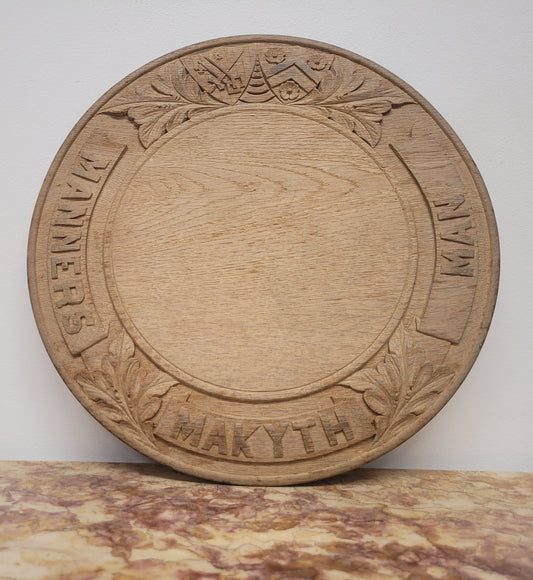 Antique circular Oak bread board carved with “Manners Makyth Man” and the arms of Winchester College England. It is in good original condition, please view photos as they help form part of the description.