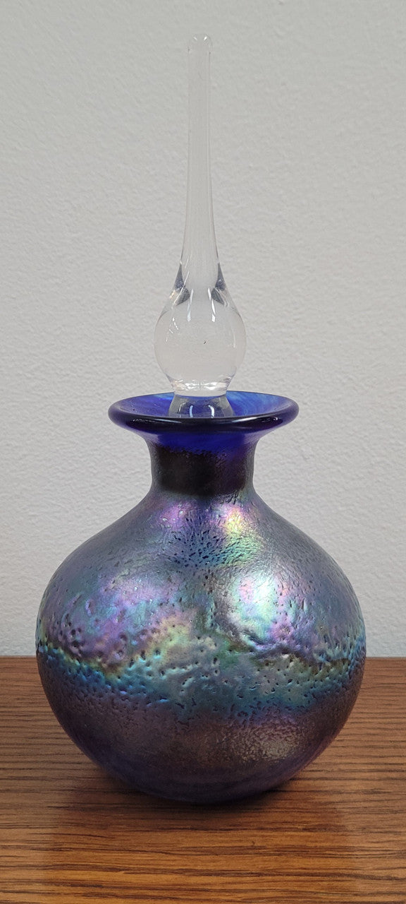 Stunning iridescent hand blown perfume bottle. Beautiful peacock blue, purple colours. Signed on base with clear glass stopper.