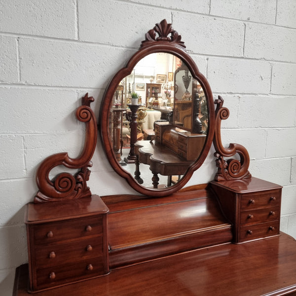 Victorian Mahogany duchess dressing table with tilt mirror on scrolled supports. It has seven trinket drawers and lift up storage. It is in good original condition and has been sourced locally.