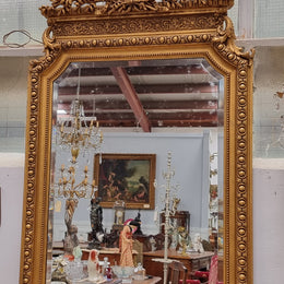 A stunning Napoleon III gilt mantle mirror with its original mirror. The top of the mirror is decorated with a beautiful laurel wreath and detailed decorative carving throughout. It is in good original condition with the bevelled mirror showing natural aging please view photo's.