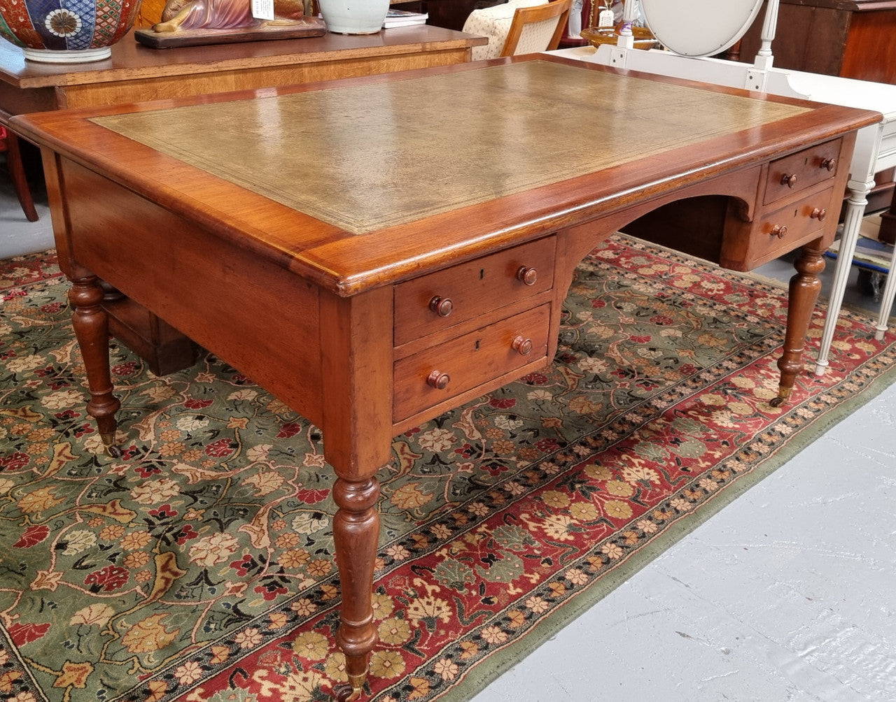 Australian Cedar full partners desk with attractive tooled leather top, four drawers either side and on caster wheels.  In good original detailed condition.