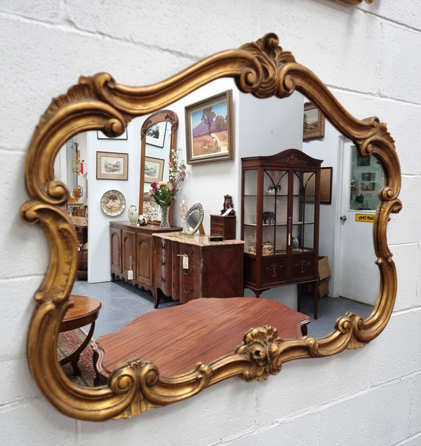 French Louis XV style wood carved and gilded mirror. Mirror is original and showing signs of age. It has been sourced from France and  in good original condition.