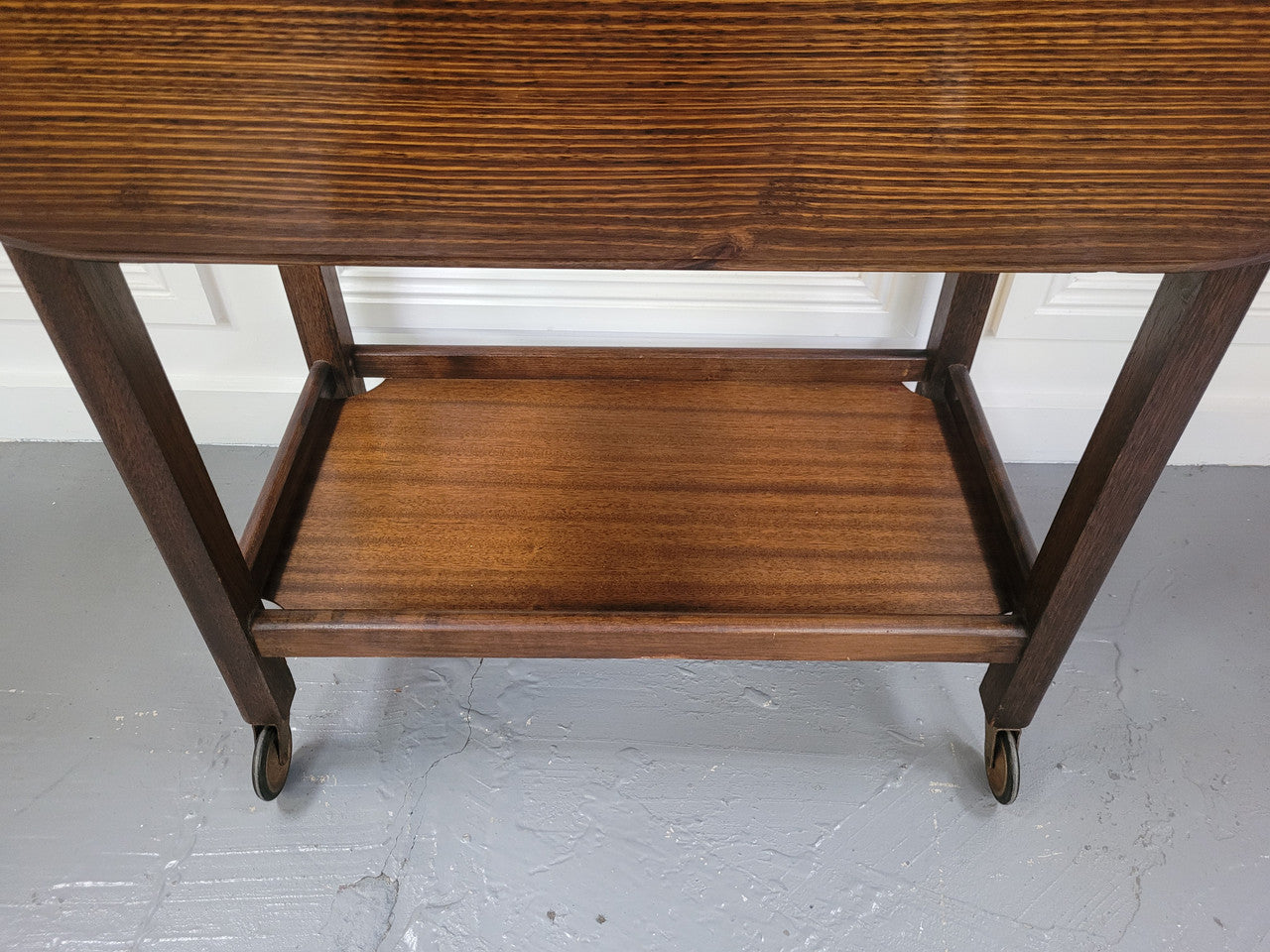 Oak drop leaf auto trolley on wheels. Both sides open up to make a larger table. It is in good original detailed condition.