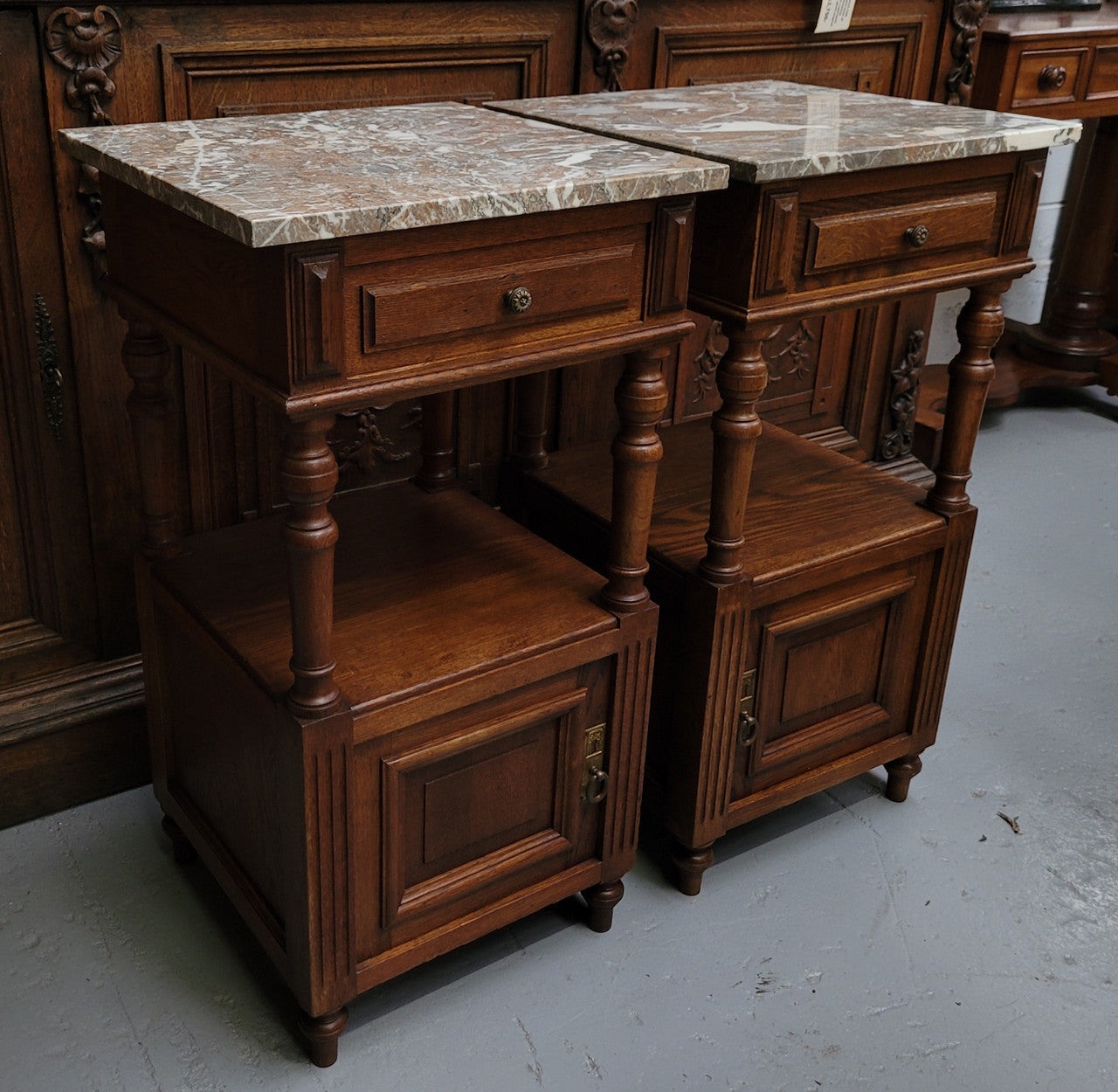 Pair of French Antique Oak marble top bedsides Henry II style. They have a drawer, cupboard and an open shelf for all your storage needs. They have been sourced from France and are in good original detailed condition.