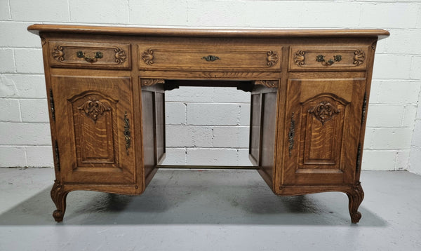 Fabulous French oak carved partners desk with a lovely parquetry top. It has three drawers and two cupboards on one side and two cupboards on the other side with no functioning drawers. It is in good original detailed condition.