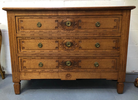Lovely carved early 19th Century French Oak commode. There are three drawers with decorative drawer pulls and is in good original detailed condition.