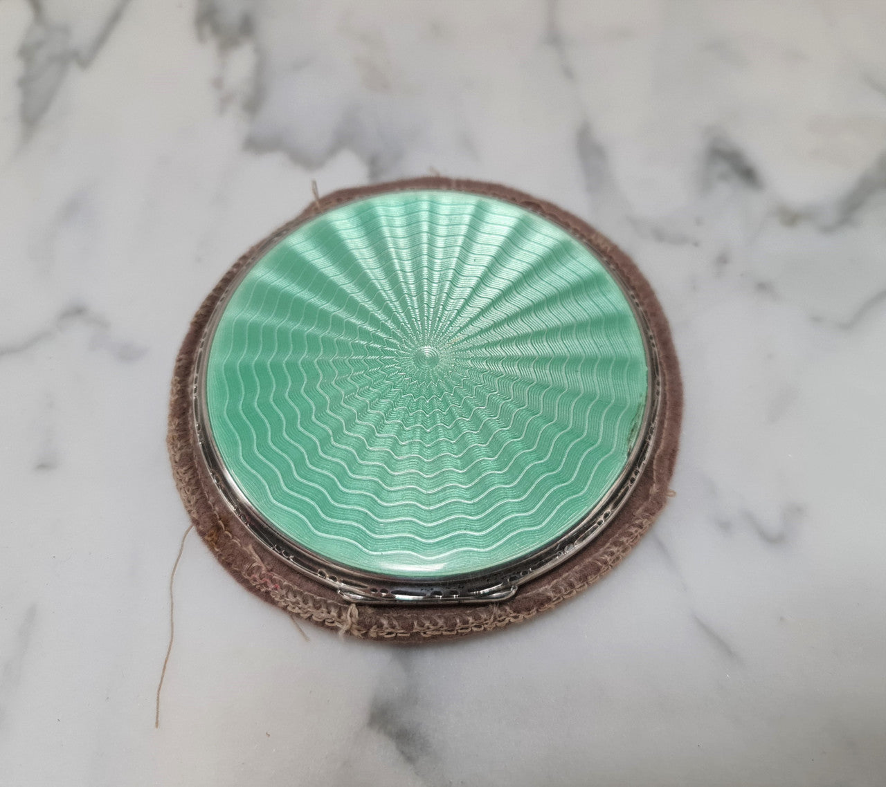 This beautiful sterling silver compact with interior mirror has a stunning mint green guilloche top in very good condition . It is marked "Birmingham 1937".