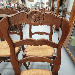 Set of six Louis XV style French Oak rush seat dining chairs. These chairs are very sturdy and have been professionally re-glued to ensure long lasting strength and sturdiness. They are in very good original detailed condition.