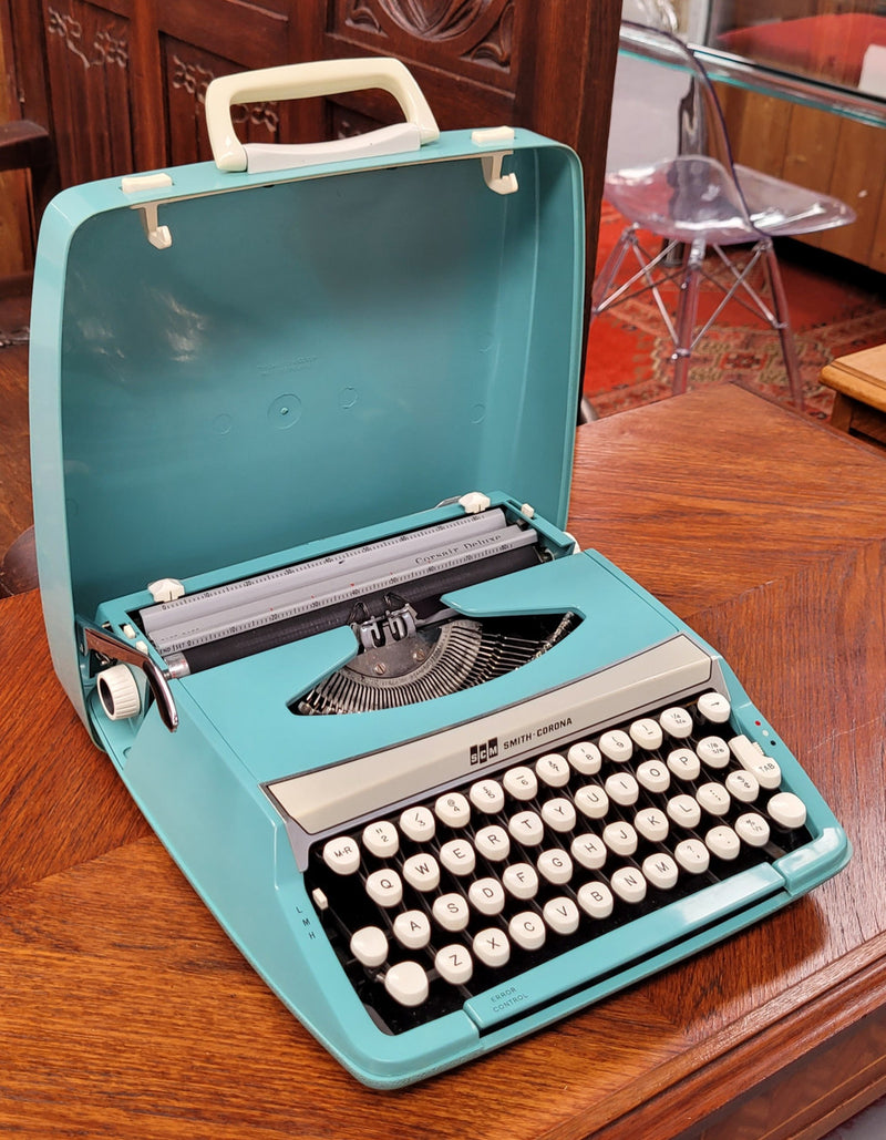 1960's Smith Corona Corsair deluxe portable typewriter. It is in working condition with a used ribbon, and comes with everything pictured. It has been sourced locally.