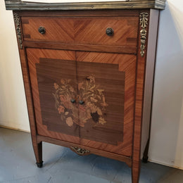 Louis 16th style marquetry inlaid side cabinet with a pierced brass gallery surrounding a marble top. It has two doors open up to storage with one shelf and a drawer above that. In good original detailed condition.