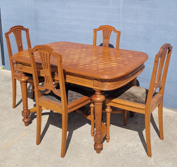 Beautiful carved French Oak dining table with a parquetry top and six matching upholstered chairs. All in good original detailed condition.
