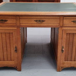 French Oak Art Deco full partners desk with leather top. Plenty of storage with both sides having three drawers at the top and two cupboards on both sides, one side has a filing section with three internal drawers and the other has a shelf on one side with three internal drawers as well. In good original detailed condition.