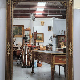Early 19th Century French gilt and simulated wood mantel mirror. It still contains its original glass which contains loads of character. It is in very good detailed condition and has had minor restorations.